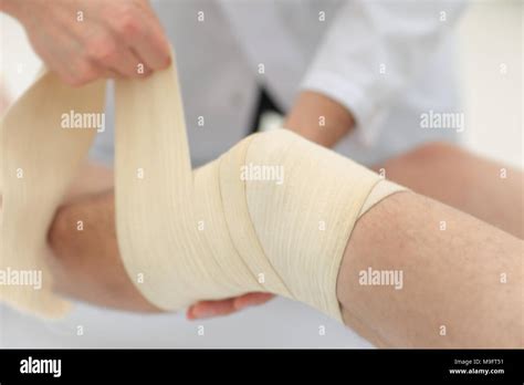 Closeup Doctor Bandaging A Patient S Leg Stock Photo Alamy