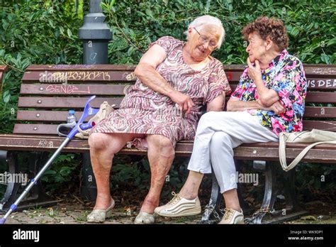 Two Senior Women Sitting On A Park Bench Elderly People Seniors