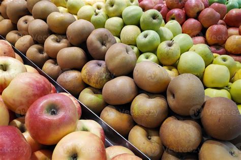 Five Varieties Of Apples Stacked Side By Side On A Market Stall