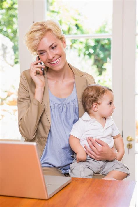 Blonde Woman With His Son Using Phone And Laptop Stock Photo Image Of Happy Business