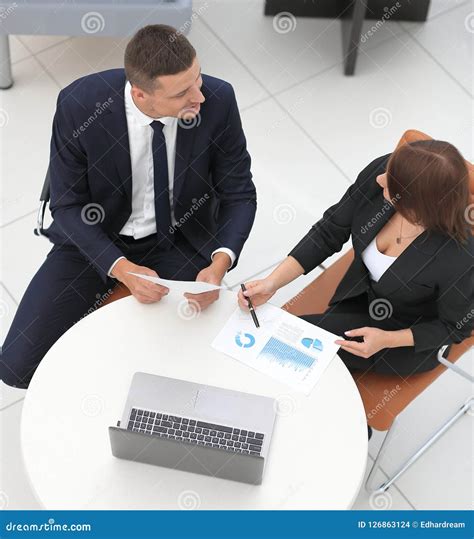 Businessman And Business Woman Discussing Marketing Scheme Stock Photo