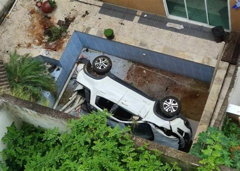 Carro despenca de barranco e cai dentro de piscina em condomínio em