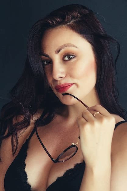 Premium Photo Beautiful Brunette Woman With Glasses Near Red Lips On A Black Background A