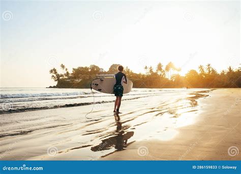 Adolescente Con Tabla De Surf Azul Y Amarillo Entrando En Las Olas Para