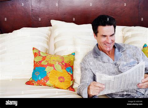 Mature Man Lying On The Bed And Reading A Newspaper Stock Photo Alamy