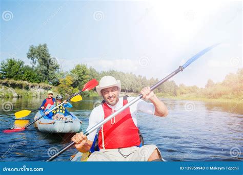 Happy Man With Two Kids Enjoying Kayak Ride On Beautiful River Father