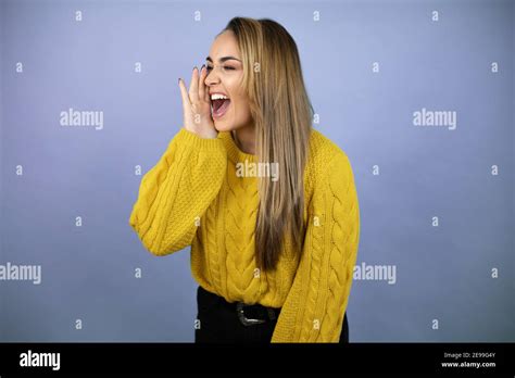 Jeune Belle Femme Blonde Avec De Longs Cheveux Portant Un Jaune Le Chandail Criant Et Criant