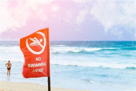 No swimming danger sign at the beach, warning sign at the beach with people swim, caution no ...