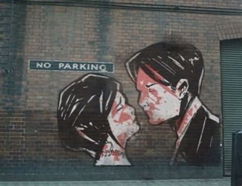 Graffiti On The Side Of A Building Depicting Two People Kissing And No