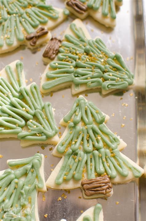 Decorated Cookies With Green Icing And Gold Sprinkles In The Shape Of