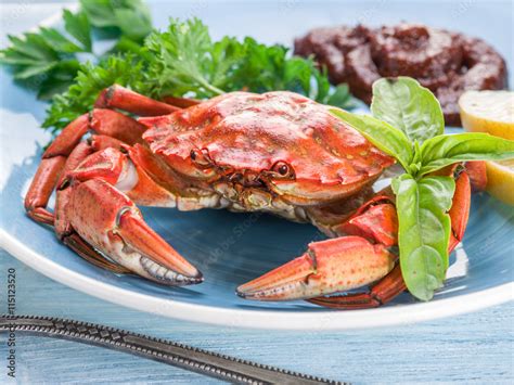 Cooked crab with lemon and herbs. Stock Photo | Adobe Stock