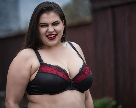 Premium Photo A Woman In A Black And Red Bra Posing For The Camera