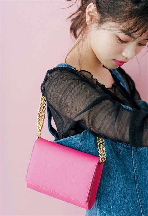 A Young Woman Holding A Pink Purse Over Her Shoulder