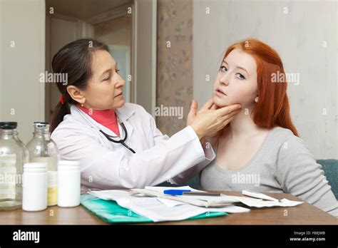 Mature Doctor Touching Neck Of Teenager Girl In Clinic Stock Photo Alamy