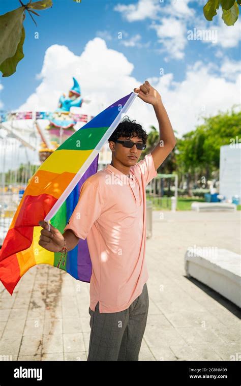 Portrait d un jeune gay hispanique regardant la caméra portant le drapeau LGBT Focus sur l