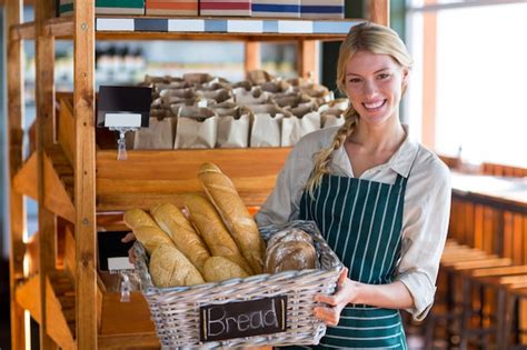 Premium Photo Smiling Female Staff Holding Basket Of Bread At Bread