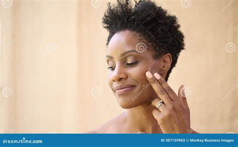 Beauty Portrait Of Mature Woman With Bare Shoulders Touching Cheek Against Natural Background