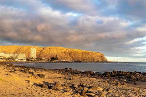 Premium Photo | A beach with a golden rock in the background