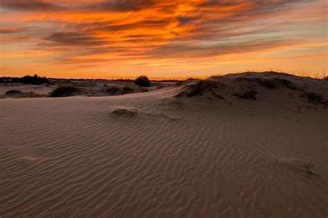 Puesta de sol sobre las dunas de arena en el desierto paisaje árido del