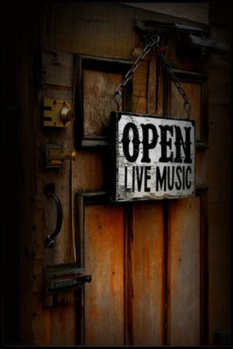 An Open Sign Is Hanging On The Wall Next To A Violin And Other Musical