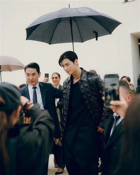 A Man Holding An Umbrella In Front Of Other People