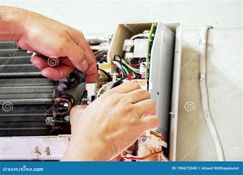 Closeup Hands Of Electric Repair Technician Fix An Electronic Board Of