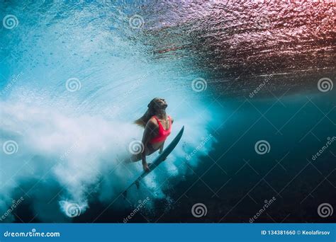 Sporty Surfer Woman Dive Underwater With Under Barrel Wave Stock Photo