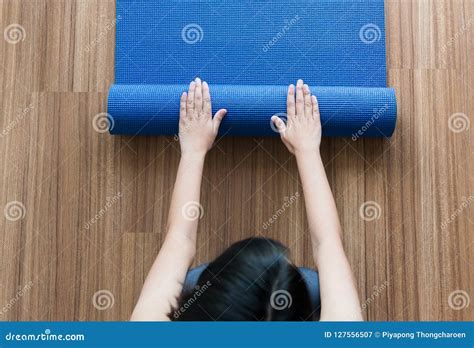 Woman Hand Rolling Or Folding Blue Yoga Mat After A Workoutexercise