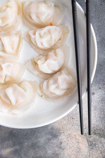 Premium Photo | A bowl of dumplings with chopsticks and a pair of ...