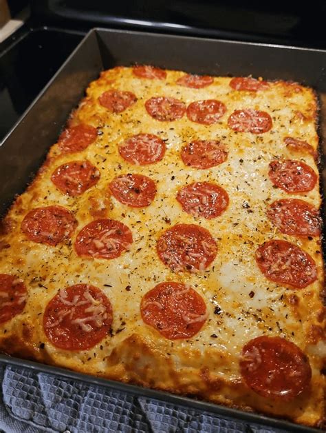 a square pizza with pepperoni and cheese in a pan