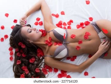 Busty Lingerie Model Luxuriating On Satin Stock Photo