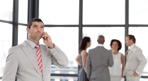 Premium Photo Charming Businessman Holding A Phone At Workplace With