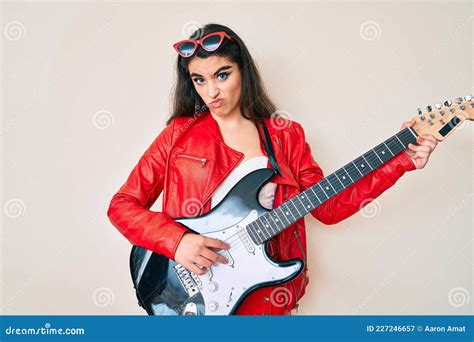 Una Adolescente De Brunette Que Toca Guitarra Eléctrica Escéptica Y Nerviosa Frunciendo El Ceño