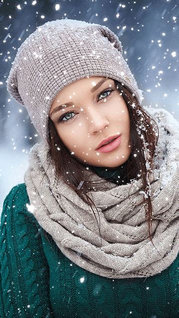 A Woman Wearing A Hat And Scarf In The Snow