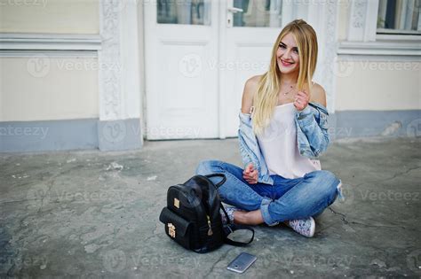 fille blonde porte un jean avec sac à dos posé contre la vieille porte 8661138 Photo de stock