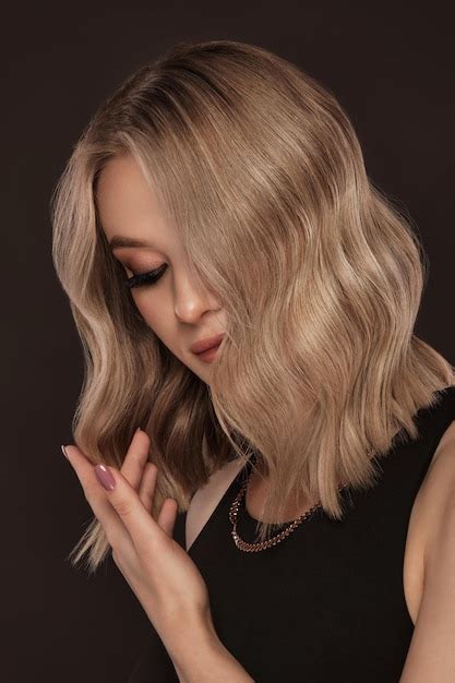 Belle fille blonde avec des cheveux parfaitement bouclés et un visage et des cheveux de beauté