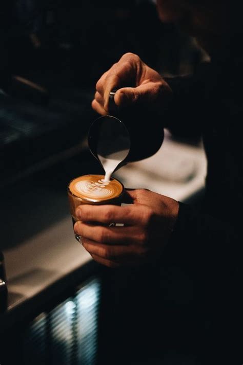 A Person Pouring Something Into A Cup