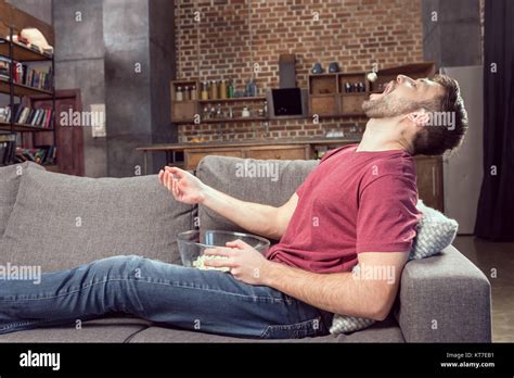 Man Eating Popcorn While Watching Movie At Home Stock Photo Alamy