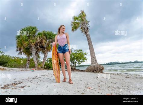Lovely Blonde Model Enjoying A Summers Day While Preparing To Surf On The Ocean With Her Boogie