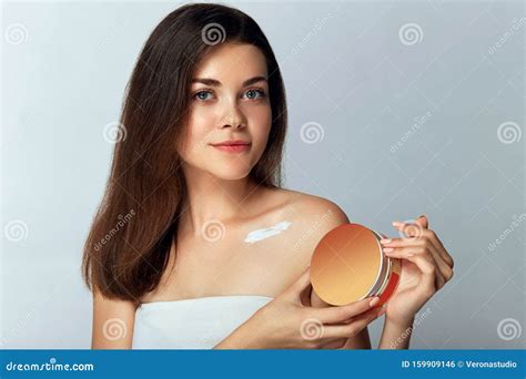 Beauty Concept Woman Holds A Cosmetic Cream In Her Hand And Spreads It