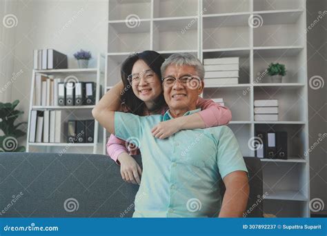 A Father And Daughter Sat In The Living Room Happily Spending Time