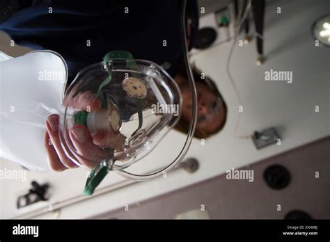 Female EMT Giving Patient Oxygen In The Back Of An Ambulance Stock