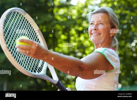 Getting ready to serve - Tennis technique. Senior woman preparing to ...