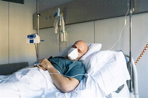 Male Patient Sleeping On Bed In Hospital Stock Photo