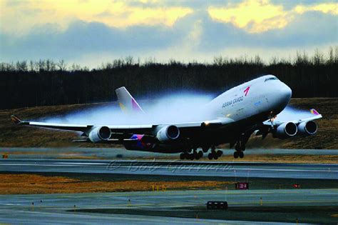 1 A Boeing 747 at takeoff on a humid day with condensation cloud above ...