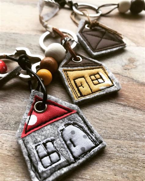 Three Key Chains With Different Designs On Them Sitting On A Wooden