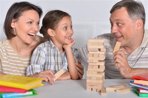 Familia Feliz Sentada A La Mesa Y Jugando Con Bloques De Madera Imagen