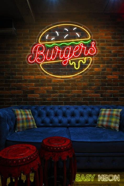 A Blue Couch In Front Of A Brick Wall With A Neon Burger Sign On It