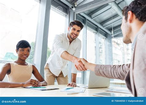 Businessmen Shaking Hands And Ending Business Meeting In Office Stock