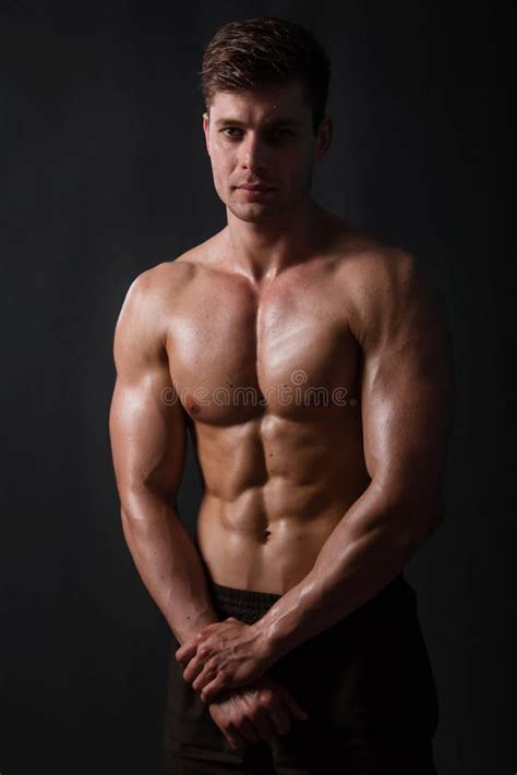 Muscular Bodybuilder Posing With A Naked Torso Against A Black Background Stock Photo Image